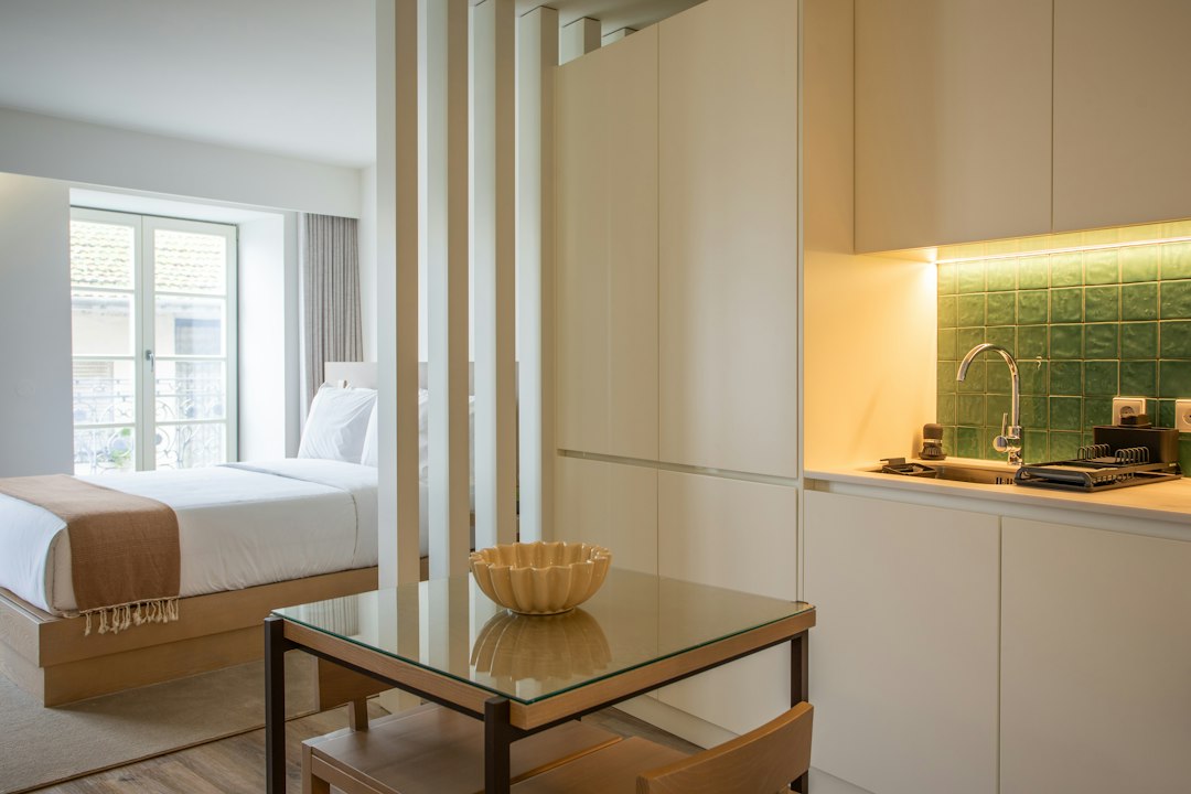 compact studio apartment interior dramatic lighting split living sleeping zone